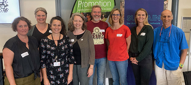 roundtable participants standing in a group together smiling