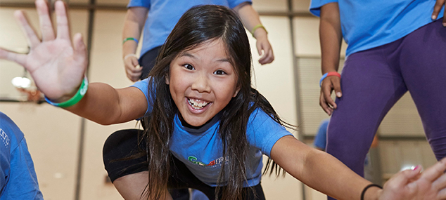 girl smiles with arms outstretched, wearing Go4Fun t-shirt