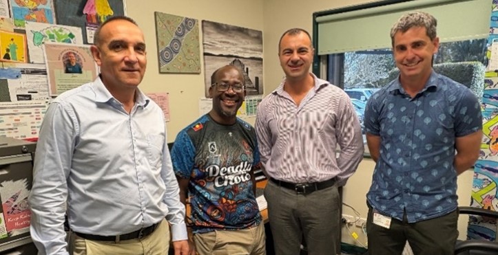 4 men standing smiling