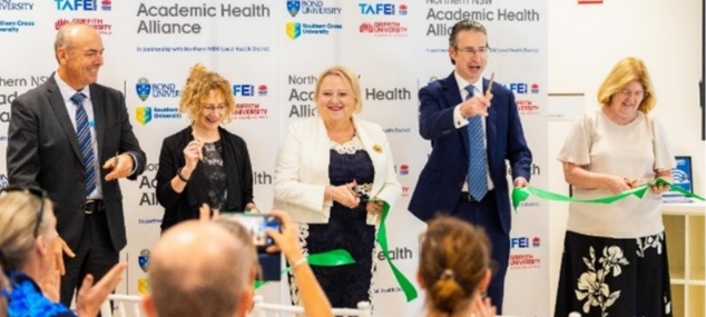 5 people stood on a stage presenting on behalf of Academic Health Alliance