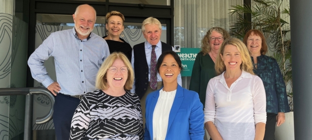 Members of the NNSWLHD Executive Team standing smiling.  8 people in total.